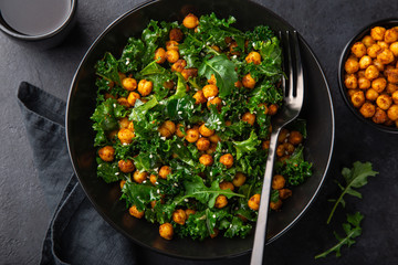 vegan kale and roasted chickpeas salad in black bowl