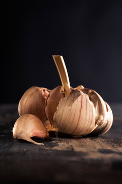 Garlic clove ripped off head over wooden surface.
