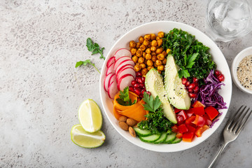 lunch bowl salad with avocado, roasted chickpeas, kale, cucumber, carrot, red cabbage, bell pepper...