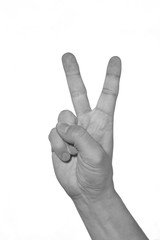 Hand showing peacy victory sign against pure. black and white.