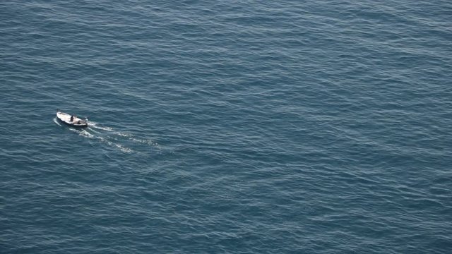 Bonassola, near Cinque Terre, Liguria. A boat in the blue sea seen from an overhanging rock. The promontory called "Salto della Lepre" offers a breathtaking view of the open sea of the Five Lands.