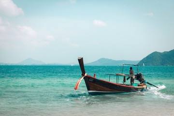 Obraz na płótnie Canvas a man riding small boat in phuket island, Thailand. Beautiful landscape of blue sea and mountains. Concept of active people enjoying holiday and sharing moments