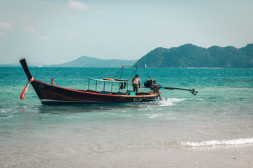 a man riding small boat in phuket island, Thailand. Beautiful landscape of blue sea and mountains. Concept of active people enjoying holiday and sharing moments