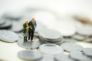 Miniature people: Happy old people standing on coins stack, Retirement planning, Emergency plan,...