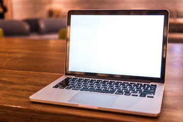 Conceptual workspace, Laptop computer with blank white screen on table, blurred background. use in...