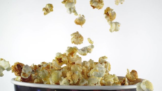 Delicious popcorn falling into a box in slow motion