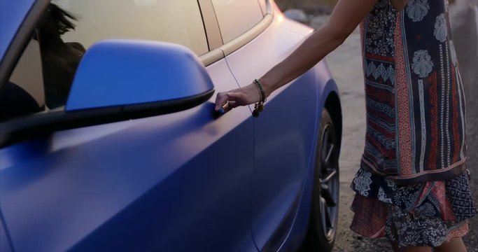 Stylish young woman opens sleek car door - up close