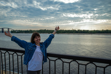 young smiling pretty woman at riverside on sunrise