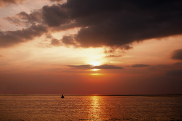 Naklejka na ściany i meble Thailand sea in evening with sun set and small boat in the middle the sea during twilight sky
