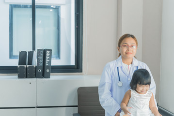 Fototapeta premium Asian doctor has a stethoscope to check his breathing and heart of a lovely girl, check the health of children,Thailand people