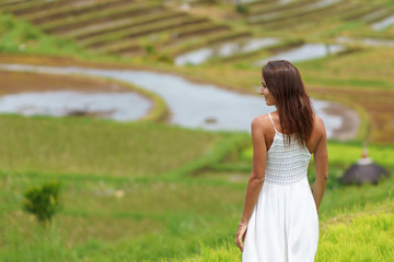 Fototapeta na wymiar Young brunette woman turning her back posing against the background of rice fields. Close up