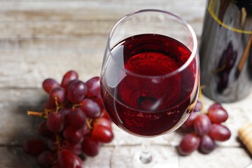 Red Wine Glass And Grapes On Wooden Table