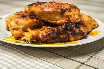 Dish of fried chicken breast fillet in a plate on the kitchen table.