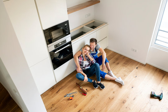 Couple assembling heir new built-in kitchen
