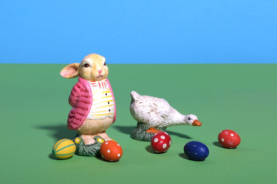 Eine Gans und ein dicker Osterhase sind auf der Wiese