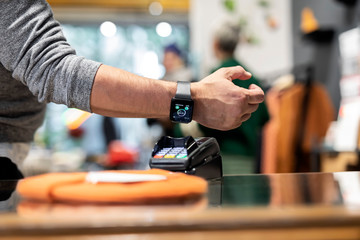 Customer paying contactless with his smartwatch