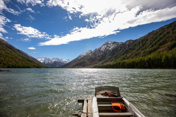 Photography of a motorboat with Life Jackets parked at river. landscape of forest and mountains
