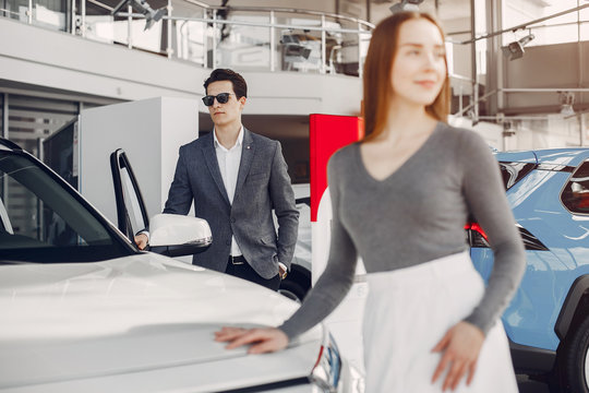 Couple buying the car. Pair in a car salon. Husband with vife choose the automobile