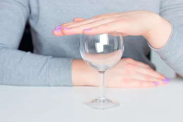Deurstickers young woman and empty glass - refusal of alcohol © itakdalee