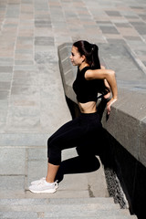 Fototapeta na wymiar Brunette fit woman stretching at the street