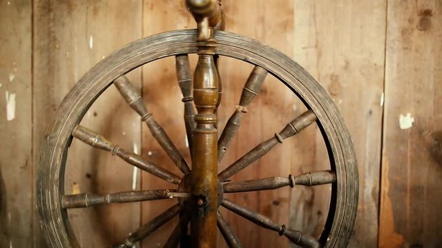 vintage wooden spinning wheel for yarn on a rustic boardwalk background