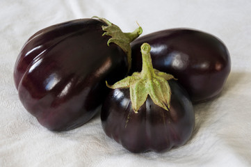 Three rape eggplants are laying on the white background. Autumn vegetables. Delicious and healthy food