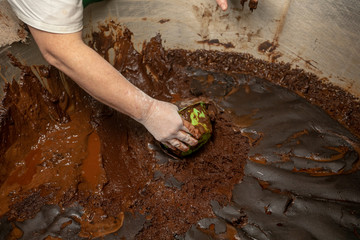 female hands knead chocolate dough in the bakery
