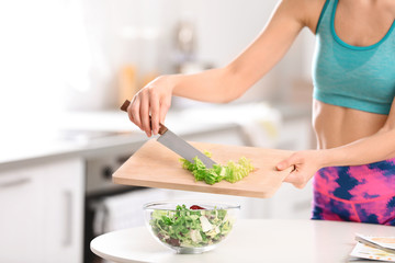 Young woman in fitness clothes preparing healthy breakfast at home, closeup
