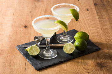 Margarita cocktails with lime in glass on wooden table