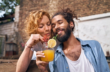 Young couple drinking cool lemonade in a backyard