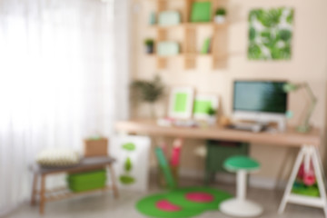 Blurred view of comfortable workplace with computer at home
