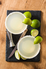 Margarita cocktails with lime in glass on wooden table. Top view