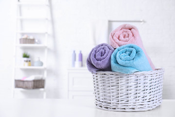 Basket with rolled fresh towels on table in bathroom. Space for text © New Africa