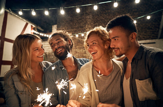 Friends having a backyard party, burning sparklers