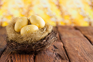 Easter eggs in the nest on wooden table