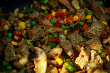 veal meat stew in a skillet with vegetables in sour cream sauce