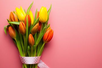 Spring flowers - a bouquet of colorful tulips on a pink background