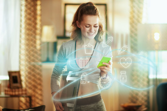 woman with smart scale tracking weight in a fit app in phone - Powered by Adobe