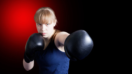 Sporty girl doing boxing exercises, making direct hit