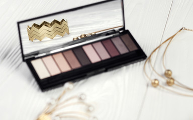 Golden bracelet reflection in eye shadow mirror