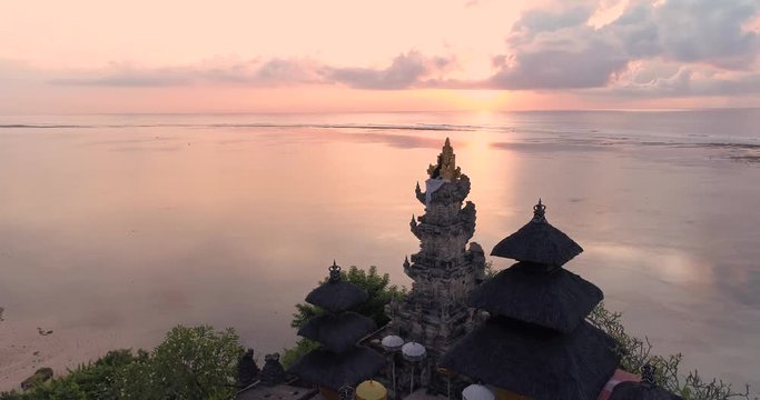 Aerial top view of Pura Geger temple at sunrise on the ocean, Bali. 4K