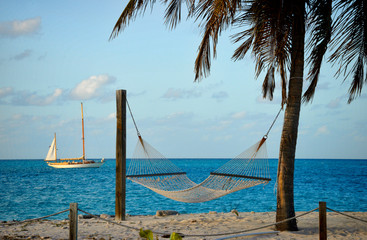 Bahama Sea Breeze with an anchored sailboat and hammock on the beach