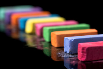 Obraz premium Close-up row of colorful chalk isolated on black background