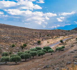 Fototapeta na wymiar Panoramic landscape with asphalt road and mountains over blue cloudy sky in Western Greece