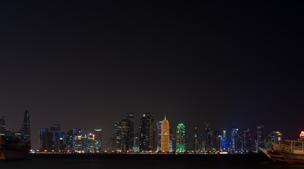 Fototapeta premium Doha city skyline night view, Qatar. view of the night city. free palce for text. night sky, high-rise buildings, luxury luminous buildings
