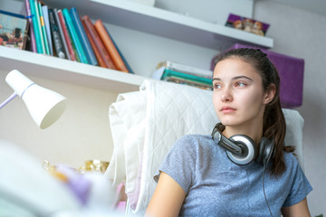 portrait of teen girl with headphones in her room