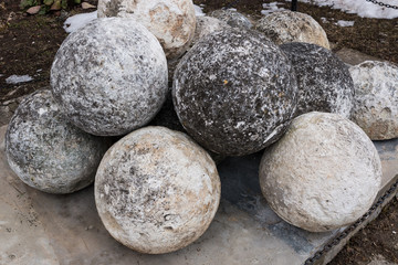 Fototapeta na wymiar Stone balls on a stone pedestal. The cores are made for throwing a combat catapult. Close up.