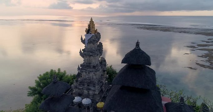 Aerial top view of Pura Geger temple at sunrise on the ocean, Bali. 4K