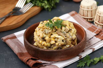 Salad with beans, parsley and champignons in a brown bowl over a dark background