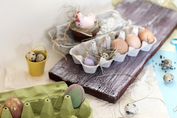 Chicken and quail eggs, toy chicken, hay, Easter decor on a light background